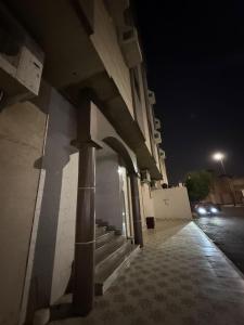 a building with stairs and a street at night at نزل العقيق بحي الجامعة in Medina