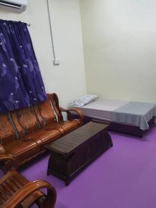 a living room with a couch and a bed at Lavender 8B Homestay in TanjongMalim