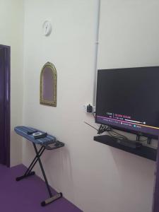 a flat screen tv sitting on a stand in a room at Lavender 8B Homestay in TanjongMalim