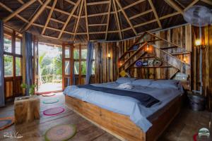 a bedroom with a large bed with a wooden ceiling at Iraboti Eco Resort Sundarban in Dhāngmāri Forest Office