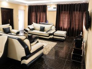 a living room with couches and chairs and a television at Tee's Place in Coker