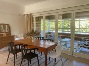 a dining room with a wooden table and chairs at Namoi Dreaming Spacious parkview residence in Narrabri