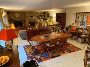 a living room with a wooden table and chairs at Les Terrasses de Rostevel in Brech