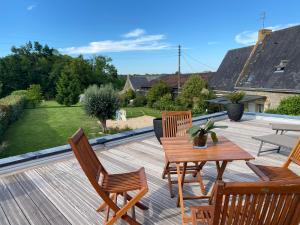 a wooden deck with a wooden table and chairs at Les Terrasses de Rostevel in Brech