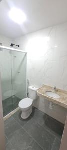 a bathroom with a toilet and a sink and a shower at Hospedaria Lençóis in Barreirinhas