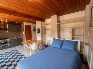 a bedroom with a blue bed and a kitchen at Appartement confortable avec cuisine équipée - API-1-52-759 in Granges-Aumontzey