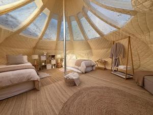 a bedroom with a tent with a bed and a rug at Forest Hillside Glamping Retreat in Lochiel