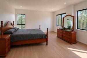 a bedroom with a bed and a dresser and a mirror at Redhill Batemans Bay in Batemans Bay