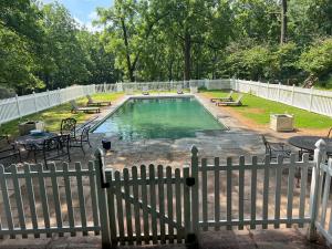 a pool with benches and a fence in a yard at Walnuts in Owings Mills