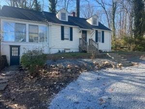 a white house with a porch and a driveway at Walnuts in Owings Mills