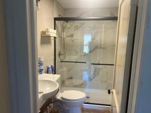 a bathroom with a shower and a toilet and a sink at Walnuts in Owings Mills +14 photos