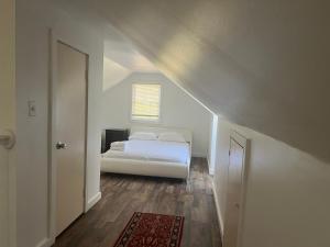 a bedroom with a white bed in a attic at Walnuts in Owings Mills