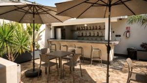 a patio with a table and chairs and umbrellas at Hotel Casa Vivaldi in Mérida