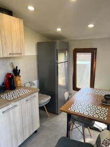 a kitchen with a stainless steel refrigerator and a table at The Orchard Manor in Ociu