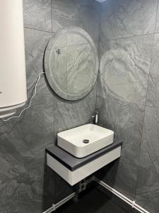 a bathroom with a sink and a mirror at The Orchard Manor in Ociu