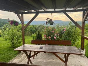 a wooden bench sitting under a gazebo with flowers at The Orchard Manor in Ociu +22 photos