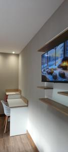 a room with a tv on a wall at Riviera Sanary Praia, Conforto e Tranquilidade in Serra