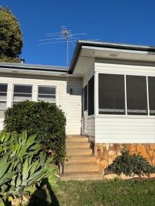 a white house with a staircase in front of it at Namoi Dreaming Spacious parkview residence in Narrabri