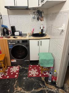 a kitchen with a sink and a washing machine at Mamaia Sea Breeze Garsonieră in Constanţa
