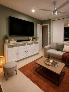 a living room with a couch and a flat screen tv at The Sanctuary on William - Nature Reserve Hideaway in Ormiston
