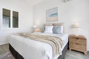 a white bedroom with a large bed and a window at Alexandra on the Pacific in Mooloolaba +41 photos
