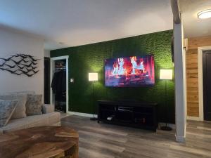 a living room with a tv on a green wall at 2BR House Perfect for Olympic NP Adventures in Port Angeles