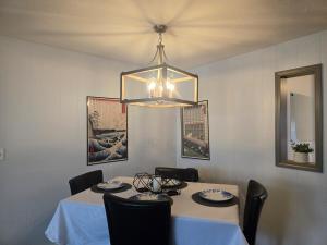 a dining room with a table and a chandelier at 2BR House Perfect for Olympic NP Adventures in Port Angeles +3 photos