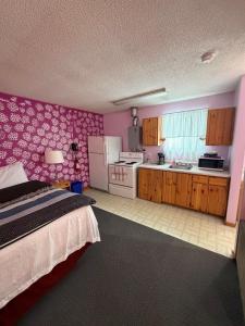 ein Schlafzimmer mit Bett und eine Küche in der Unterkunft Glenview Cottages in Sault Ste. Marie