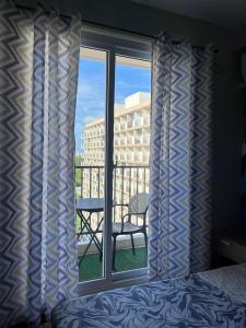 a bedroom with a window with a view of a balcony at Saekyung Condominium in Suba