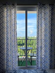a room with a window with a table and a balcony at Saekyung Condominium in Suba