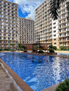 a large swimming pool in front of two large buildings at Saekyung Condominium in Suba +5 photos