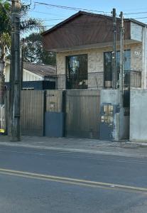 a house on the side of a street with a fence at Apartmento-Studio in União da Vitória