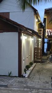 a white building with a staircase on the side of it at Bem Me Quer - Hospedagem in Trindade
