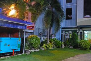 a blue building with palm trees in front of it at Point Vista Transient Accomodation in Daet