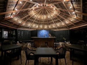 a restaurant with a large ceiling with a stage at Safira Resort in Santa Fe