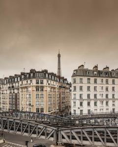 a bridge over a river with buildings and a tower at Eiffel Petit Louvre in Paris