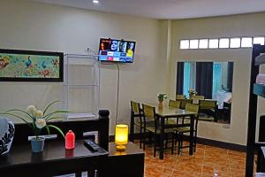 a restaurant with tables and chairs and a television on the wall at Point Vista Transient Accomodation in Daet