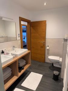 a bathroom with a sink and a toilet and a mirror at Appartements Danijela in Fügenberg +83 photos
