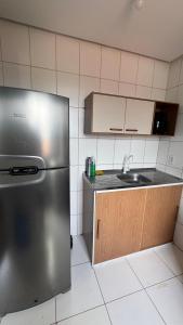 a kitchen with a stainless steel refrigerator and a sink at Apartamento mobiliado in Marabá
