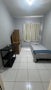 a bedroom with a bed and a table and a window at Apartamento mobiliado in Marabá
