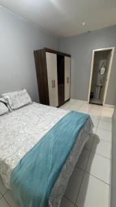 a bedroom with a bed with a blue blanket on it at Apartamento mobiliado in Marabá +7 photos