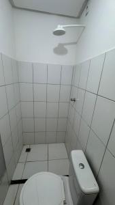 a white bathroom with a toilet and a sink at Apartamento mobiliado in Marabá