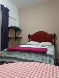 a bedroom with a bed with a red blanket at Pousada Taiwan in Ubatuba