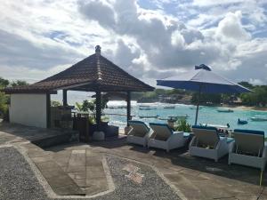 a gazebo with chairs and an umbrella next to the water at Rady Lembongan in Nusa Lembongan +13 photos