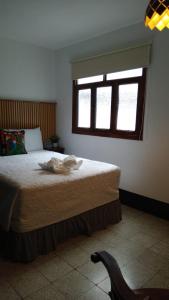 a bedroom with a large bed with a window at Hotel & Restaurante Teresàs Bistro in Antigua Guatemala +1 photo