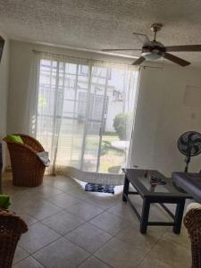 a living room with a window with a ceiling fan at Casa de Mar in Acapulco