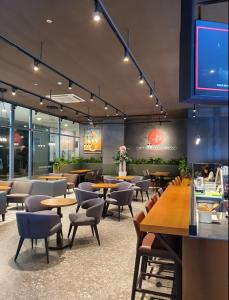 a restaurant with tables and chairs and a flat screen tv at Hotel Laonzena in Daegu