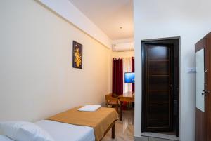 a hotel room with a bed and a desk at Park View Residency - Guest House Near Sree Padmanabhaswamy Temple in Trivandrum +16 photos