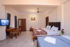 a hotel room with two beds and a desk at Park View Residency - Guest House Near Sree Padmanabhaswamy Temple in Trivandrum