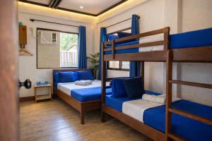 a bedroom with two bunk beds and a window at Island Lyfe Adventures Hotel - 5 Minutes from El Nido Airport & Lio Beach in El Nido